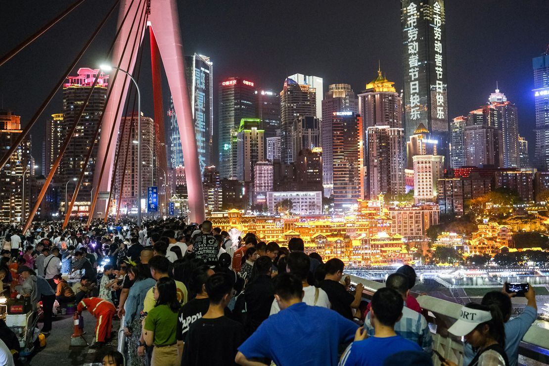 Tourists visit the Qiansimen Jialing River Bridge during the May Day holiday on May 1, 2023 in Chongqing, China.